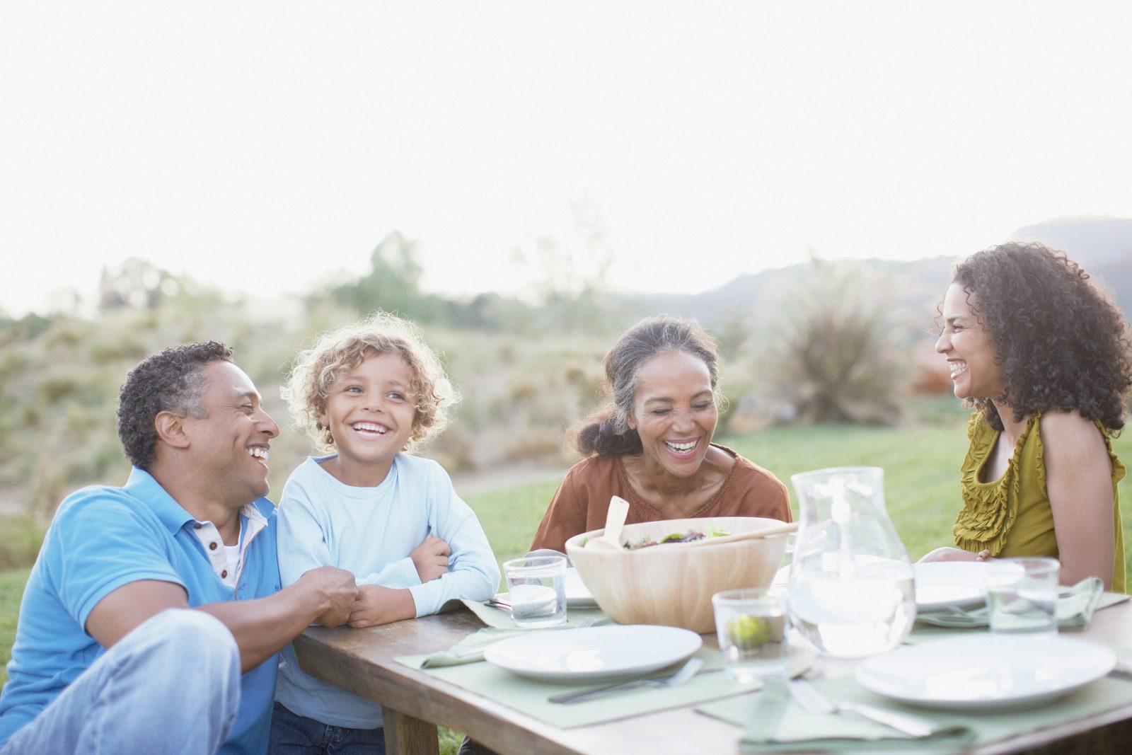 A family laughing together around an outdoor table